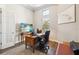 Home office space with a wood desk, ergonomic chair, and a window for natural light, promoting productivity at 4745 Benito Ct, Lakewood Ranch, FL 34211