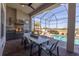Screened-in patio with an outdoor kitchen, dining table, and view of the pool and golf course at 4745 Benito Ct, Lakewood Ranch, FL 34211
