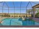 Screened-in pool with spa and view of lush greenery and other homes in a sunny neighborhood at 4745 Benito Ct, Lakewood Ranch, FL 34211