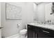 Stylish powder room with a dark vanity, marble countertop, decorative wall art, and a neutral color palette at 4745 Benito Ct, Lakewood Ranch, FL 34211