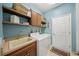 Well-lit laundry room with washer, dryer, sink, wood cabinets, shelves and decor at 531 Latitude Ln, Osprey, FL 34229