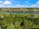 Aerial view showcases community homes surrounding a serene lake and lush landscaping at 557 Marsh Creek Rd, Venice, FL 34292