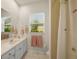 Well-lit bathroom with a single vanity, framed mirror, and shower with neutral finishes at 557 Marsh Creek Rd, Venice, FL 34292