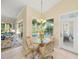 Cozy breakfast nook with a glass table, seating for four, and a view of the pool at 557 Marsh Creek Rd, Venice, FL 34292