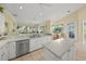 Bright kitchen featuring white cabinets, updated appliances and views of the living area at 557 Marsh Creek Rd, Venice, FL 34292