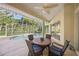 Screened lanai with table and chairs overlooking a sparkling pool surrounded by tropical landscaping at 557 Marsh Creek Rd, Venice, FL 34292