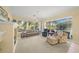 Bright living room with large windows and comfortable seating overlooking the pool at 557 Marsh Creek Rd, Venice, FL 34292