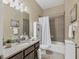 Well-lit bathroom featuring a vanity with granite countertop, tub-shower combo, and tile flooring at 9214 Raes Creek Pl, Palmetto, FL 34221