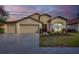 Charming home featuring a three-car garage, manicured landscaping, and inviting front entrance at 9214 Raes Creek Pl, Palmetto, FL 34221