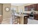 Well-equipped kitchen with granite countertops, stainless steel appliances, and seating at the island at 9214 Raes Creek Pl, Palmetto, FL 34221