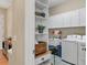 Laundry room with a washer, utility sink, shelving, white cabinets, and tile flooring at 9214 Raes Creek Pl, Palmetto, FL 34221
