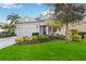 Charming single-story home with a well-manicured lawn, tidy landscaping, and an attached two-car garage at 10931 Blue Magnolia Ln, Parrish, FL 34219