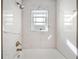 Bathroom with white marble tile, shower, and window, highlighting bright and elegant finishes at 1746 Stapleton St, Sarasota, FL 34239