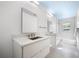 Bright bathroom featuring double sink vanity with marble countertop, large mirrors, and modern fixtures at 1746 Stapleton St, Sarasota, FL 34239