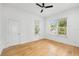 Sunlit bedroom featuring hardwood floors, a ceiling fan, and large windows overlooking the landscaped yard at 1746 Stapleton St, Sarasota, FL 34239
