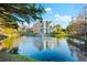 Scenic view of a two-story home overlooking a serene pond with a fountain under a sunny sky at 1746 Stapleton St, Sarasota, FL 34239