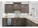 Close-up of a modern kitchen with dark wood cabinets, granite countertops, and stainless steel appliances at 1746 Stapleton St, Sarasota, FL 34239