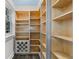 Spacious walk-in pantry with custom wood shelving and wine rack for optimal organization and accessibility at 1746 Stapleton St, Sarasota, FL 34239