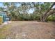 Large, private backyard showcasing mature trees, landscaping, and a storage shed at 3200 Tobero Ln, Sarasota, FL 34235