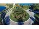Aerial view of a beautifully landscaped roundabout featuring lush greenery and palm trees at 3360 Founders Club Dr, Sarasota, FL 34240