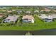 Aerial view of an estate home showcasing a screened pool, lush landscaping, and serene waterfront views at 3360 Founders Club Dr, Sarasota, FL 34240