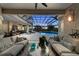 Covered outdoor patio with comfortable seating overlooks a sparkling pool and tropical landscaping at 3360 Founders Club Dr, Sarasota, FL 34240