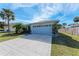 Single-story home with a spacious driveway, two-car garage, and manicured lawn at 4410 70Th E Dr, Sarasota, FL 34243
