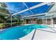 Bright, screened-in pool with sunny patio, lush landscaping, and outdoor seating at 4410 70Th E Dr, Sarasota, FL 34243