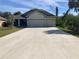 This home boasts a long driveway leading to a three car garage and is surrounded by lush greenery at 4432 Collingswood Blvd, Port Charlotte, FL 33948