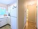 Efficient kitchen with white cabinets, appliances, and a view of the hallway and an adjacent bathroom at 5918 Palm Ln # C33, Bradenton, FL 34207