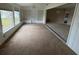 Bright living room featuring carpet floors, large windows, and ample sunlight at 600 S Neponsit Dr, Venice, FL 34293