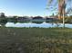 Scenic view of the pond with lush greenery, mature trees, and birds at 600 S Neponsit Dr, Venice, FL 34293