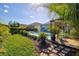 Picturesque backyard with lush landscaping, inviting pool, and charming outdoor living space at 7453 Featherstone Blvd, Sarasota, FL 34238