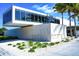 Modern Siesta Beach building with large glass windows and manicured landscaping at 7453 Featherstone Blvd, Sarasota, FL 34238