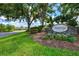 Welcome to Stonebridge on Palmer Ranch, featuring a beautiful stone sign surrounded by trees and landscaping at 7453 Featherstone Blvd, Sarasota, FL 34238