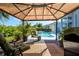 Charming gazebo with comfortable seating, overlooking a beautiful pool and landscaped yard at 7453 Featherstone Blvd, Sarasota, FL 34238