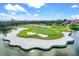 Scenic aerial view of a beautiful golf course with a sand trap surrounded by a lake at 7453 Featherstone Blvd, Sarasota, FL 34238