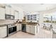 Well-lit kitchen featuring stainless steel appliances, granite countertops, and adjacent dining area at 7453 Featherstone Blvd, Sarasota, FL 34238