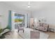 Bright living room with plush seating, a ceiling fan, and sliding glass doors leading to an outdoor pool at 7453 Featherstone Blvd, Sarasota, FL 34238