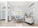 Inviting living room featuring a large arched window, neutral tones, and tile flooring at 7453 Featherstone Blvd, Sarasota, FL 34238