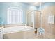 Tranquil main bathroom featuring a soaking tub and separate glass shower at 7453 Featherstone Blvd, Sarasota, FL 34238