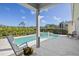 Beautiful pool and spa area surrounded by lush landscaping and a covered patio at 7453 Featherstone Blvd, Sarasota, FL 34238