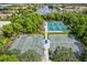 Aerial view of well-maintained tennis courts surrounded by lush trees at 7453 Featherstone Blvd, Sarasota, FL 34238