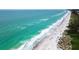 Beautiful aerial view of the shoreline with clear, turquoise water at 765 Saint Judes N Dr, Longboat Key, FL 34228