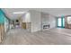 Bright living room showcasing a modern fireplace, and light gray wood flooring at 765 Saint Judes N Dr, Longboat Key, FL 34228