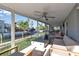 Spacious enclosed patio with canal views, featuring comfortable seating and a ceiling fan at 765 Saint Judes N Dr, Longboat Key, FL 34228