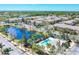 Beautiful community aerial showcasing a pool, pond, lush landscaping, and well-maintained townhome exteriors at 1605 Napoli W Dr, Sarasota, FL 34232
