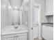 Bright bathroom showcasing a vanity sink with a large mirror and cabinet storage at 1605 Napoli W Dr, Sarasota, FL 34232