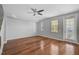 A spacious bedroom with hardwood floors, neutral walls, a ceiling fan, and natural light coming through the windows at 1605 Napoli W Dr, Sarasota, FL 34232
