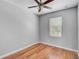 Neutral bedroom featuring hardwood floors, a ceiling fan, and a sunlit window at 1605 Napoli W Dr, Sarasota, FL 34232